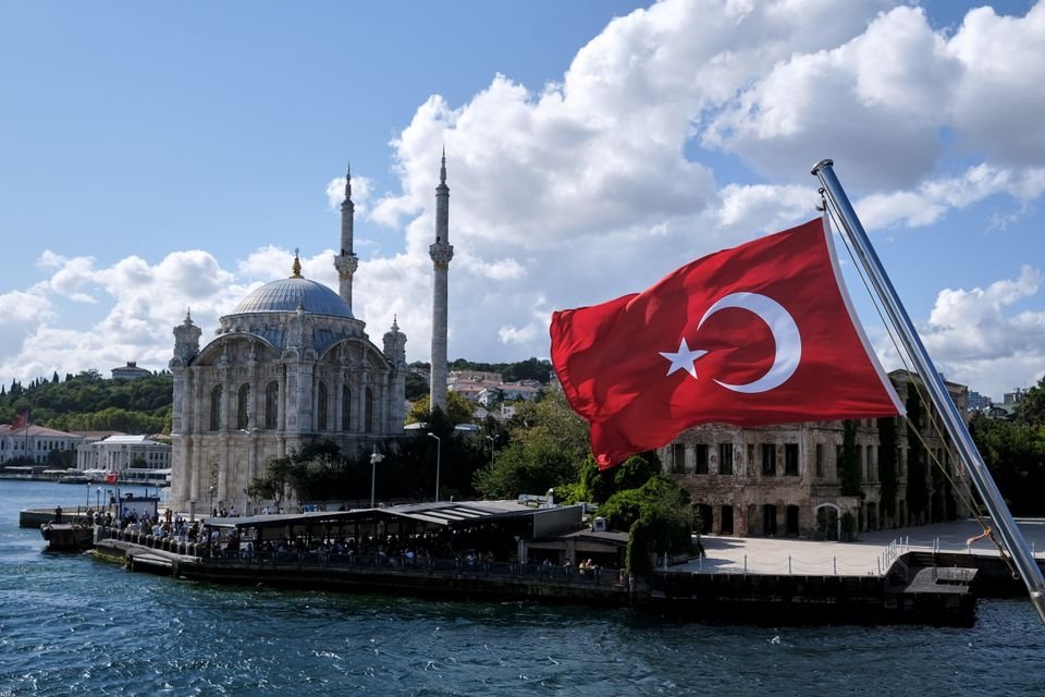 A Turkish flag is pictured on a boat with the Ortaköy Mosque in the background in Istanbul, Türkiye, Sept. 5, 2021.