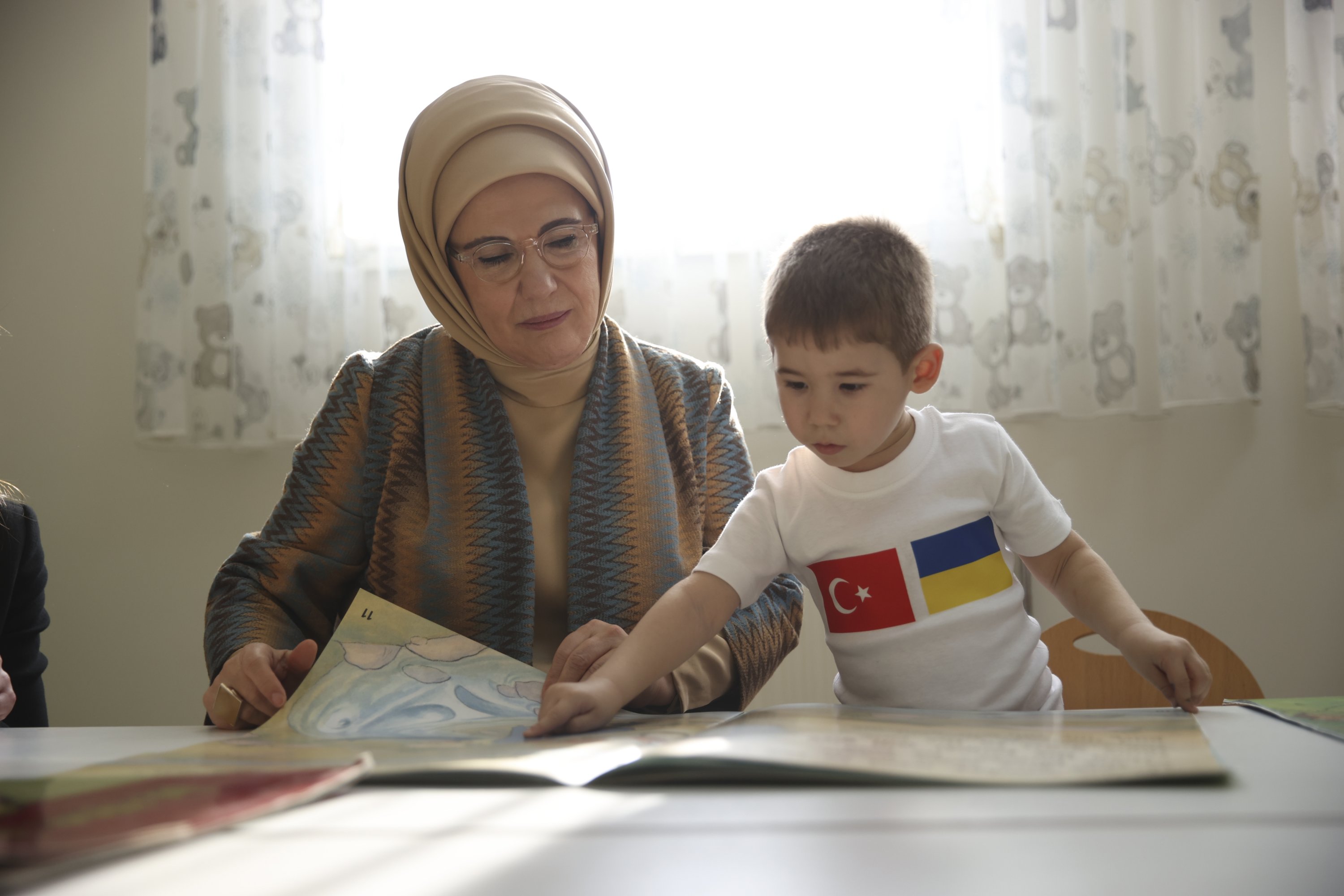 A Ukrainian boy shows his book to first lady Emine Erdoğan, in the capital Ankara, Türkiye, Dec. 1, 2022. (AA Photo)