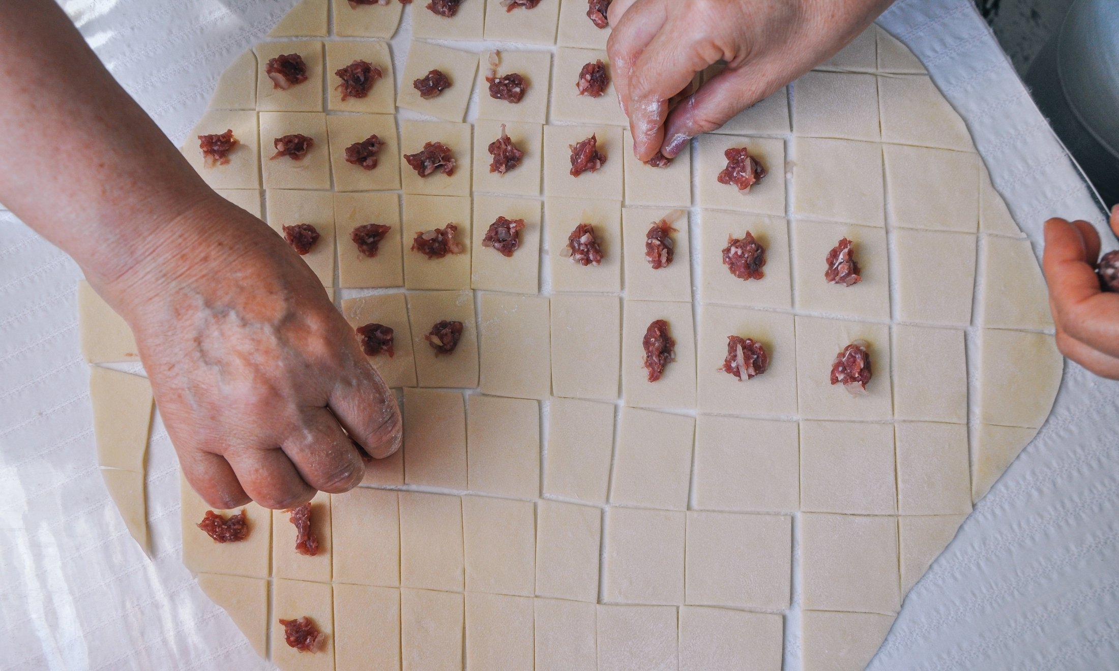 251509 Women make traditional Turkish mantı. (Shutterstock Photo)